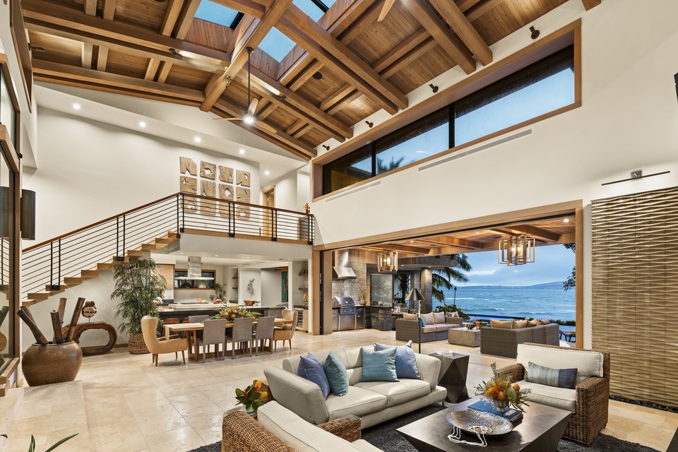 Double-height living room opening to the oceanfront terrace.