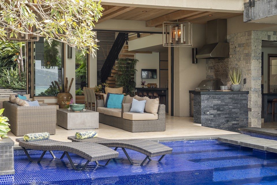Covered living area opening directly to the blue-tiled pool.