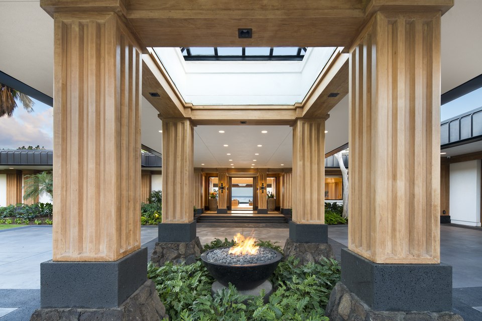Symmetrical entry court framed by stone and wood columns.