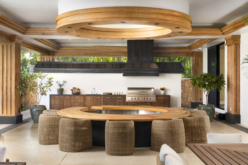 Covered outdoor kitchen and circular dining table.