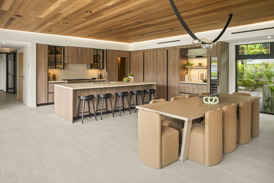 Timber-lined kitchen and dining room opening toward the pool courtyard.