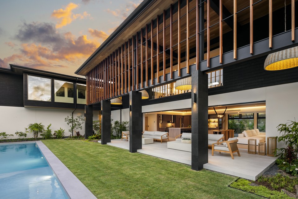 Pool and open-air living spaces at a Kāhala residence as evening light settles over the courtyard.