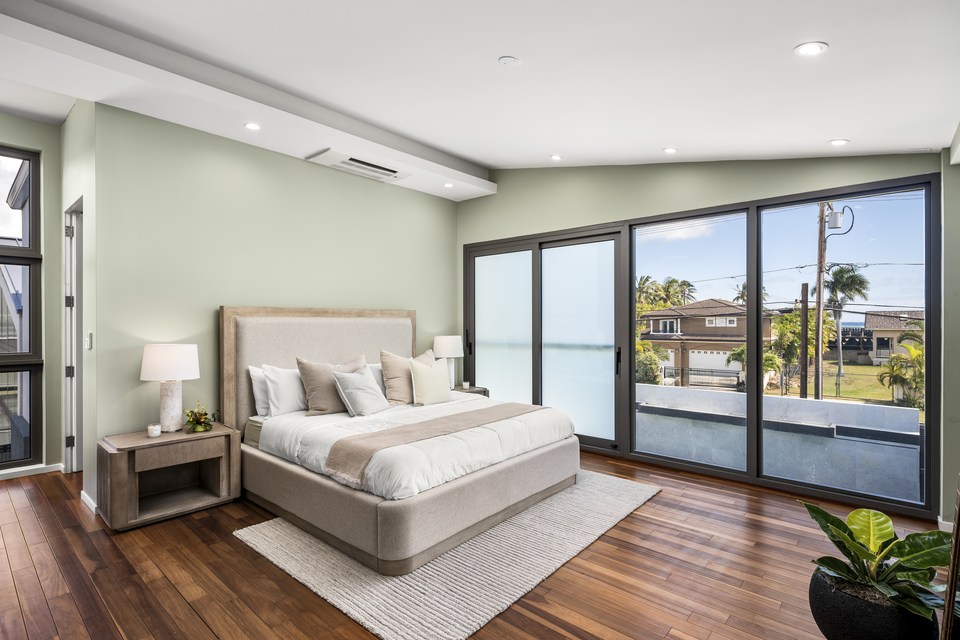 Bedroom with wood floors and a view toward the neighborhood.