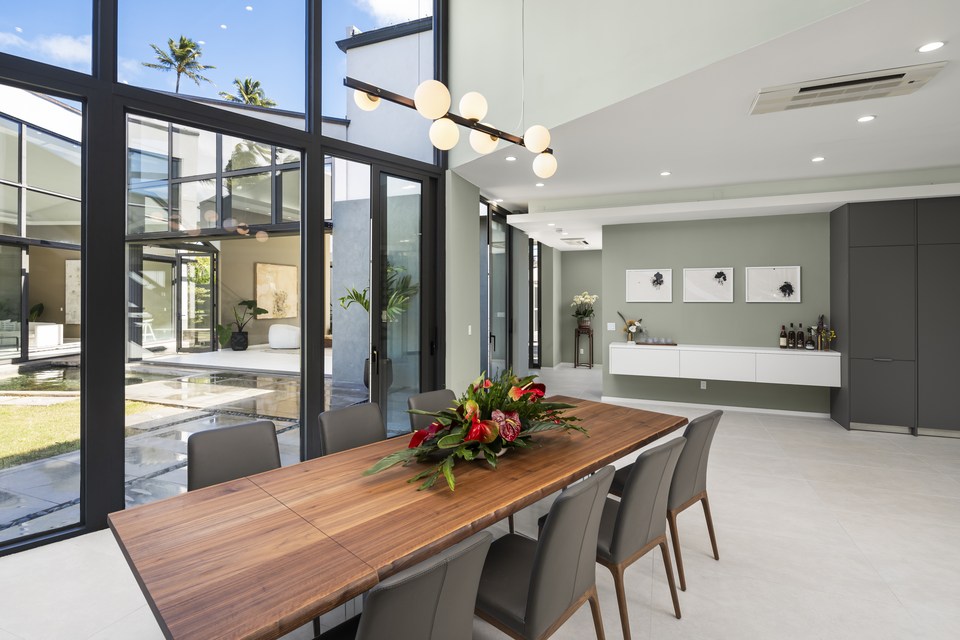 Dining room framed by tall windows and courtyard views.