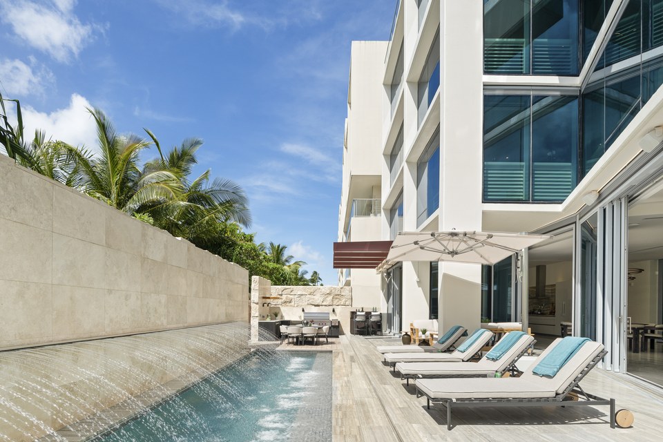 Linear pool and shaded terrace set against a contemporary Ala Moana facade.