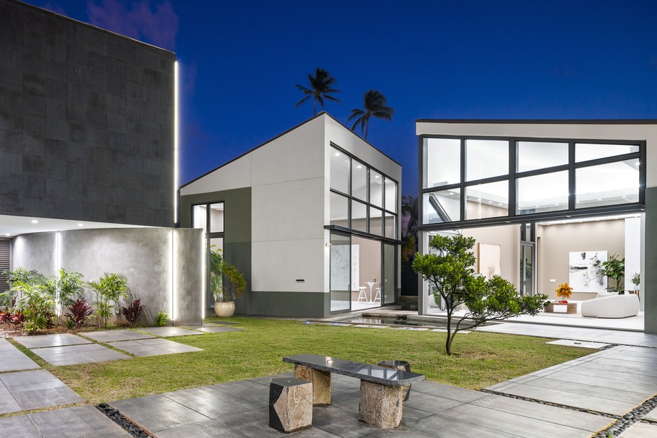 Modern Kahala residence composed around a landscaped courtyard at dusk.