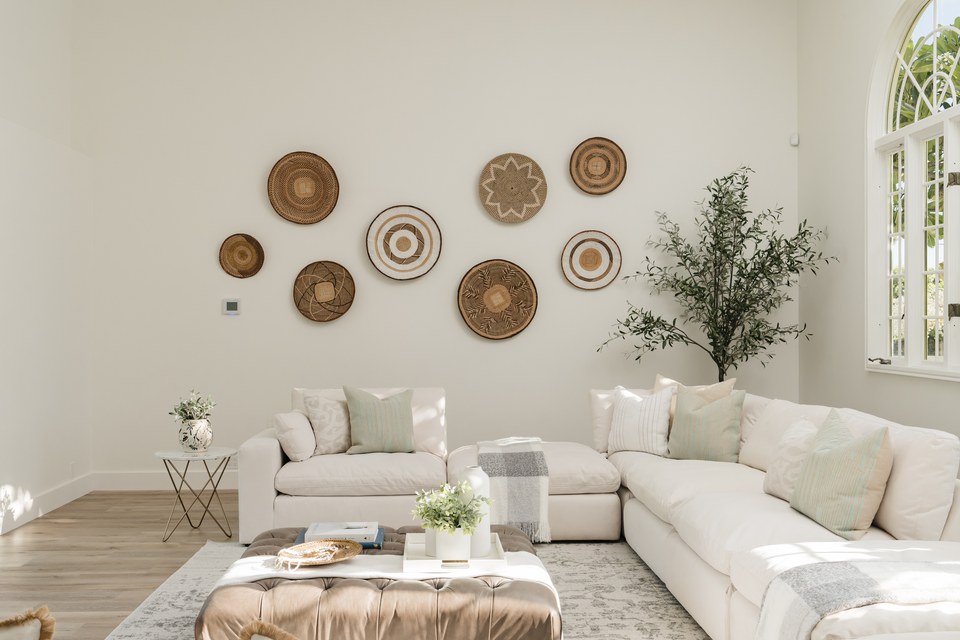 Sunlit living room with high ceilings and natural decorative details.