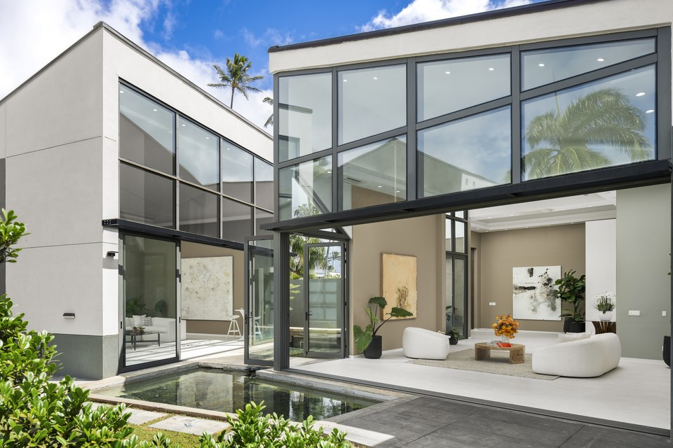 Modern courtyard residence in Kahala with glass walls and indoor-outdoor living.